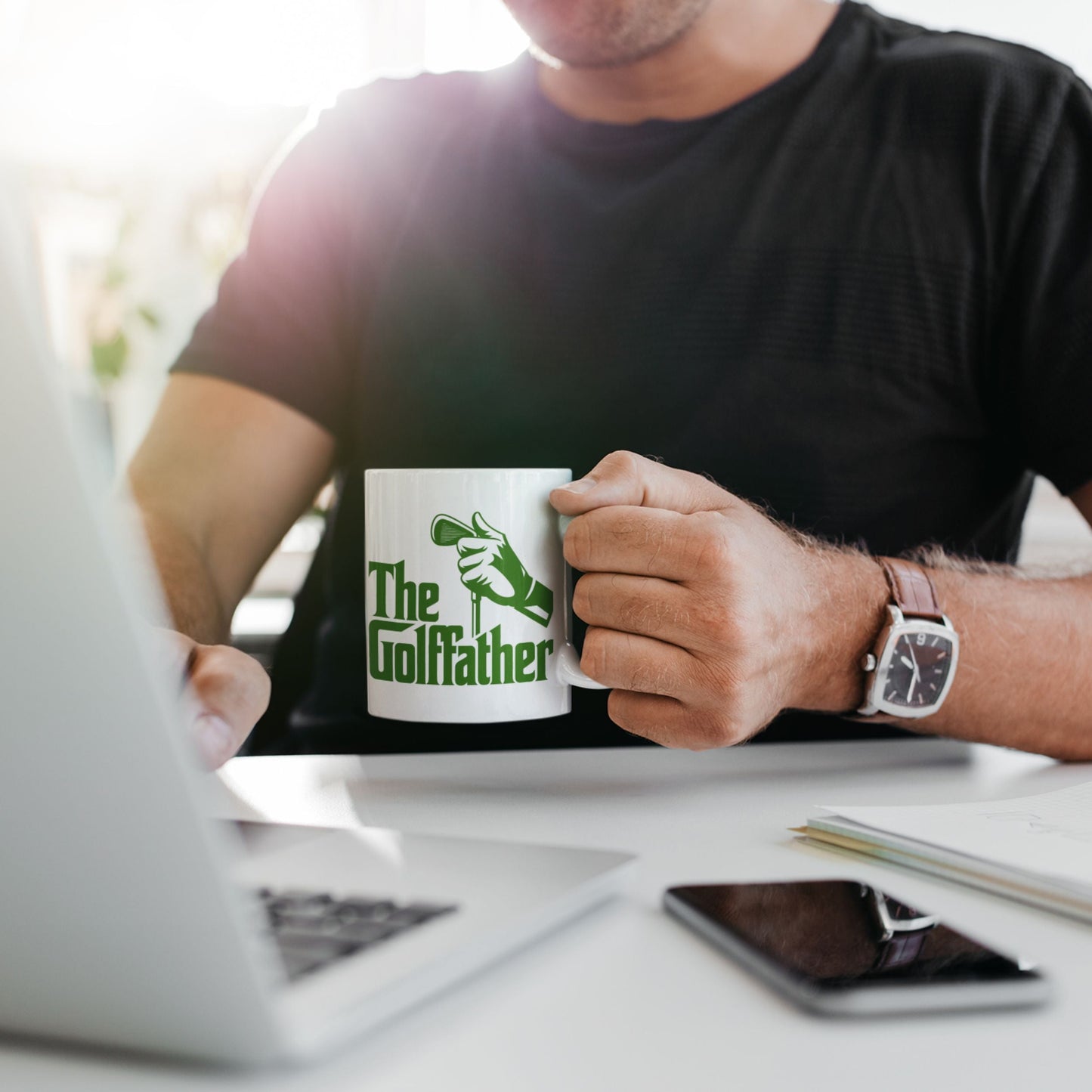 Person enjoying coffee from the Golffather Funny Coffee Mug while working, perfect for golf gifts for dad.