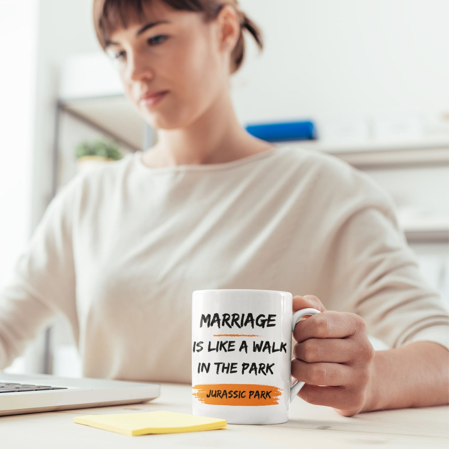 Person holding a Funny 11oz Ceramic Coffee Mug with the text 'Marriage is like a walk in the park, Jurassic Park', a fun choice for joke gifts for men.