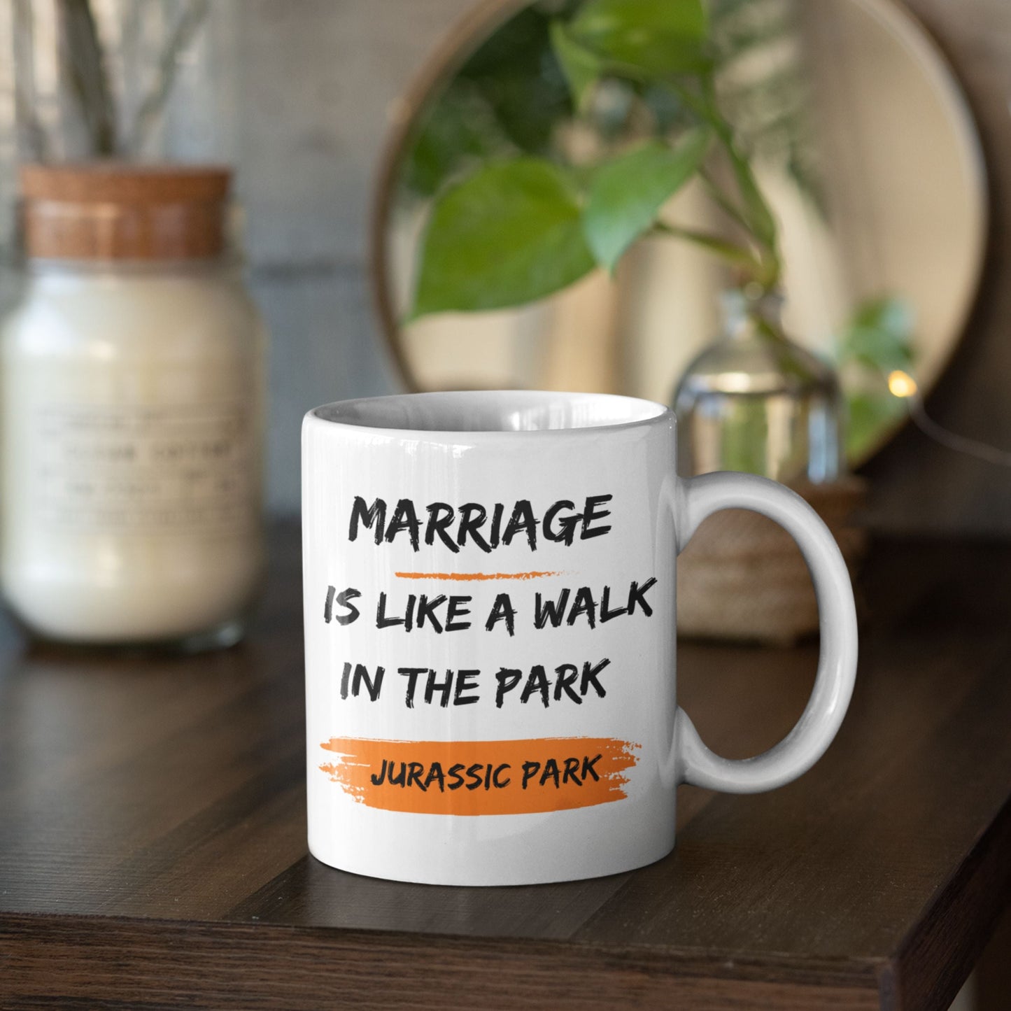 Funny 11oz Ceramic Coffee Mug on a wooden table with greenery around, featuring 'Marriage is like a walk in the park, Jurassic Park' - a fun gift idea among joke gifts for men.