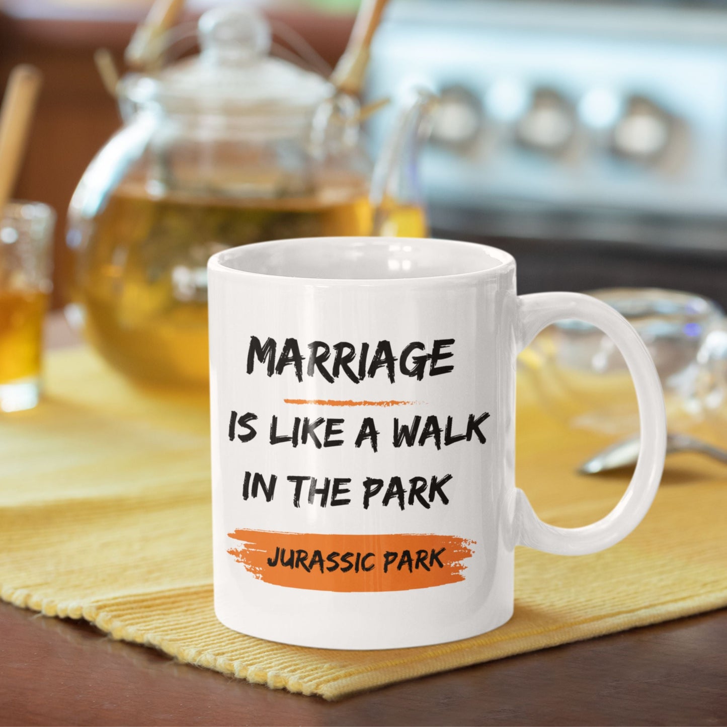 Funny 11oz Ceramic Coffee Mug on a kitchen counter with drinks, displaying 'Marriage is like a walk in the park, Jurassic Park' - perfect for joke gifts for men.