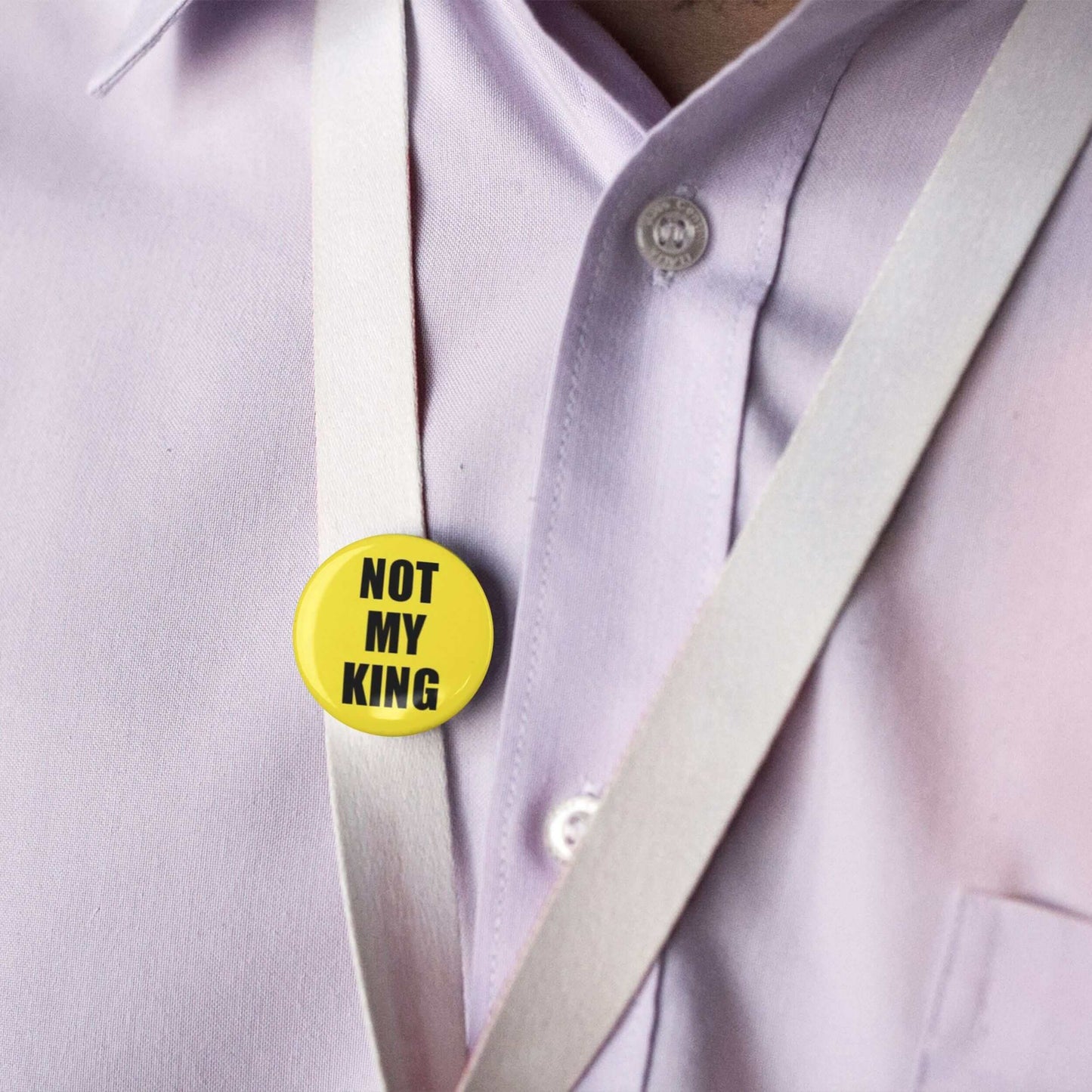 Yellow Not My King anti-monarchy pin badge on a shirt, ideal for political statements.