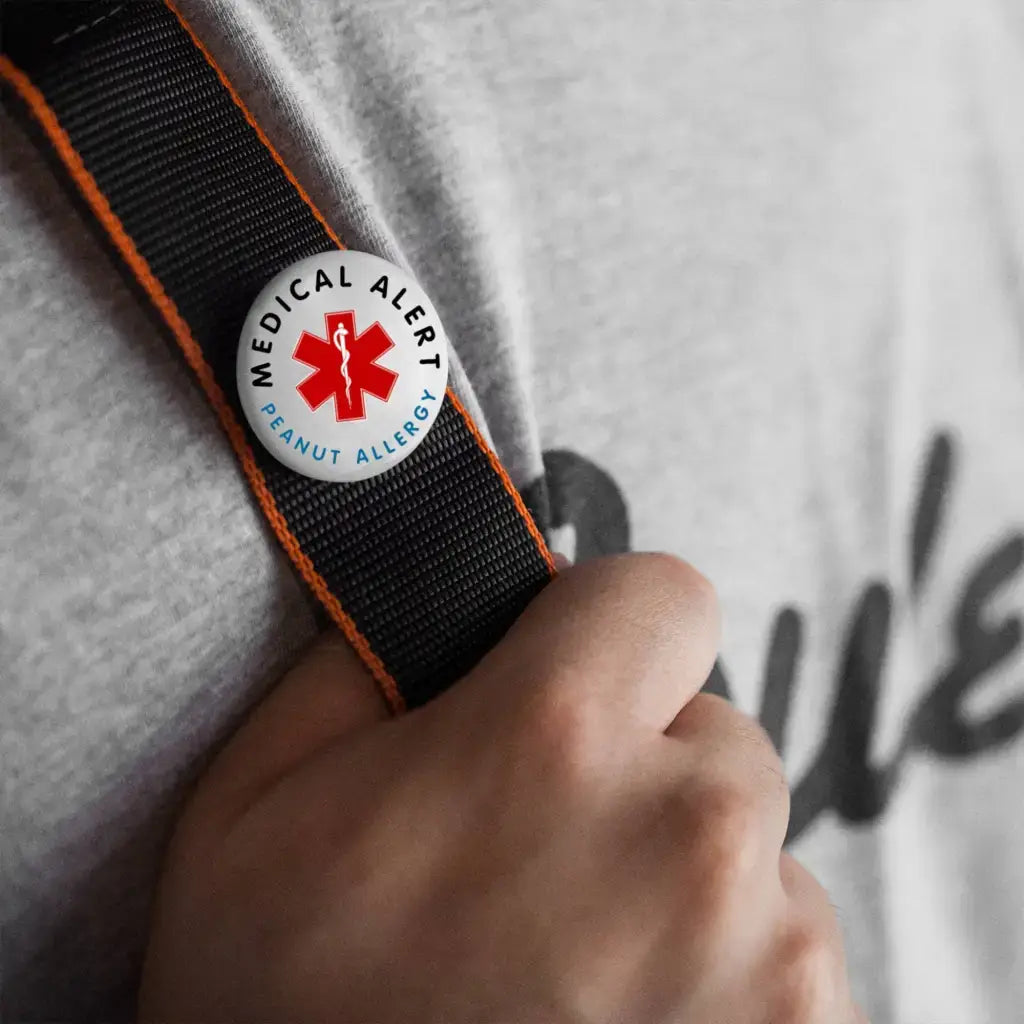 Peanut Allergy Medical Alert Logo Badge 1 in 25 mm displayed on a person's strap, demonstrating how to wear the peanut allergy badge for visibility.
