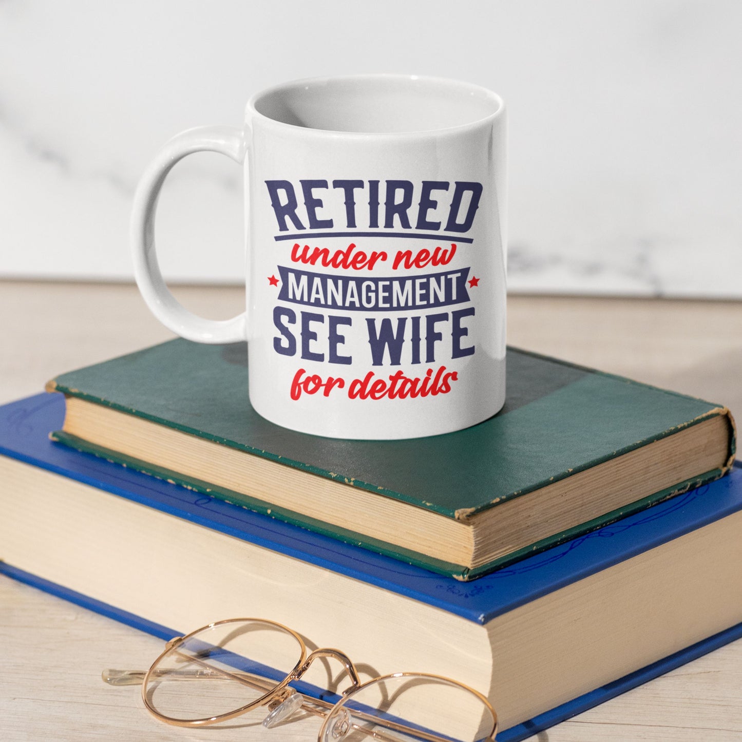 Happy Retirement Coffee Mug 2025 on top of books, a witty and practical gift for retiring colleagues.