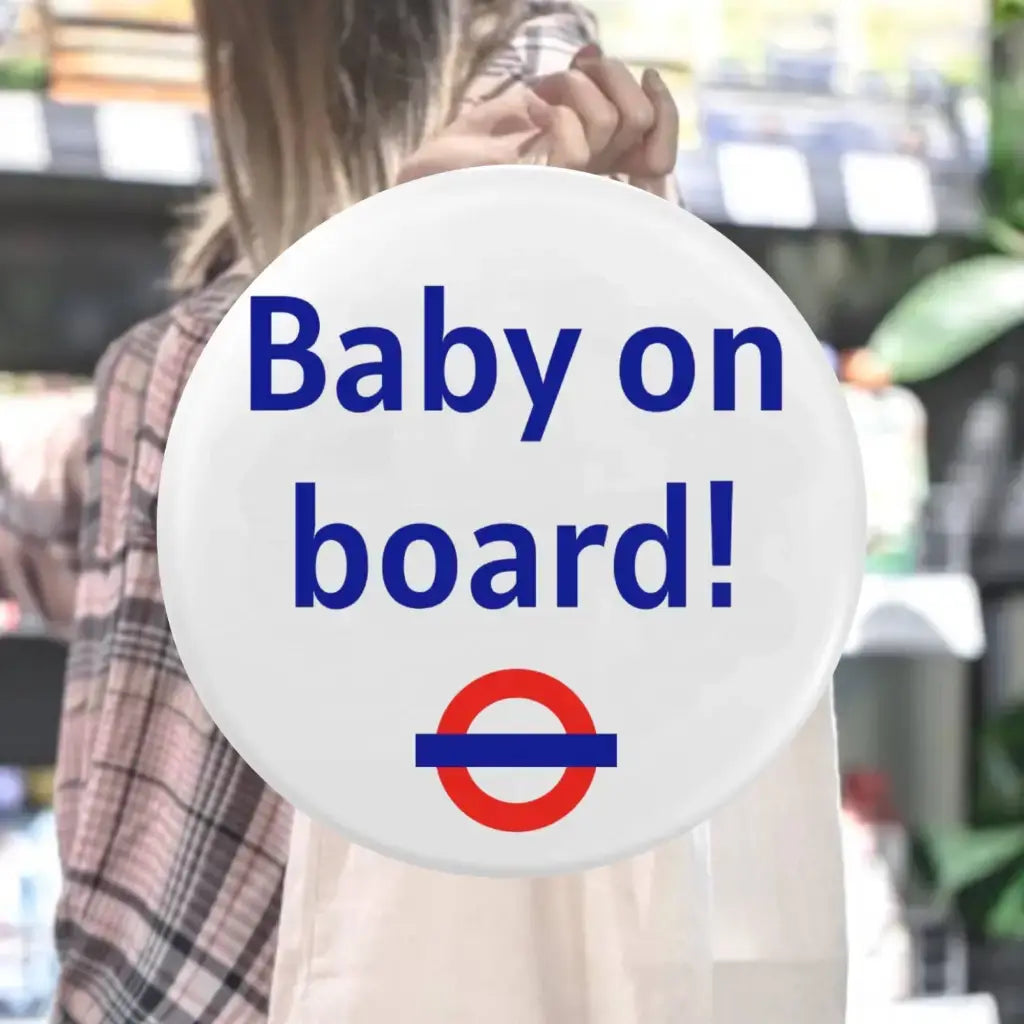 The EMU Works Baby On Board Pin displayed on a shopping bag in a store, illustrating its casual yet fun style for pregnancy announcements.