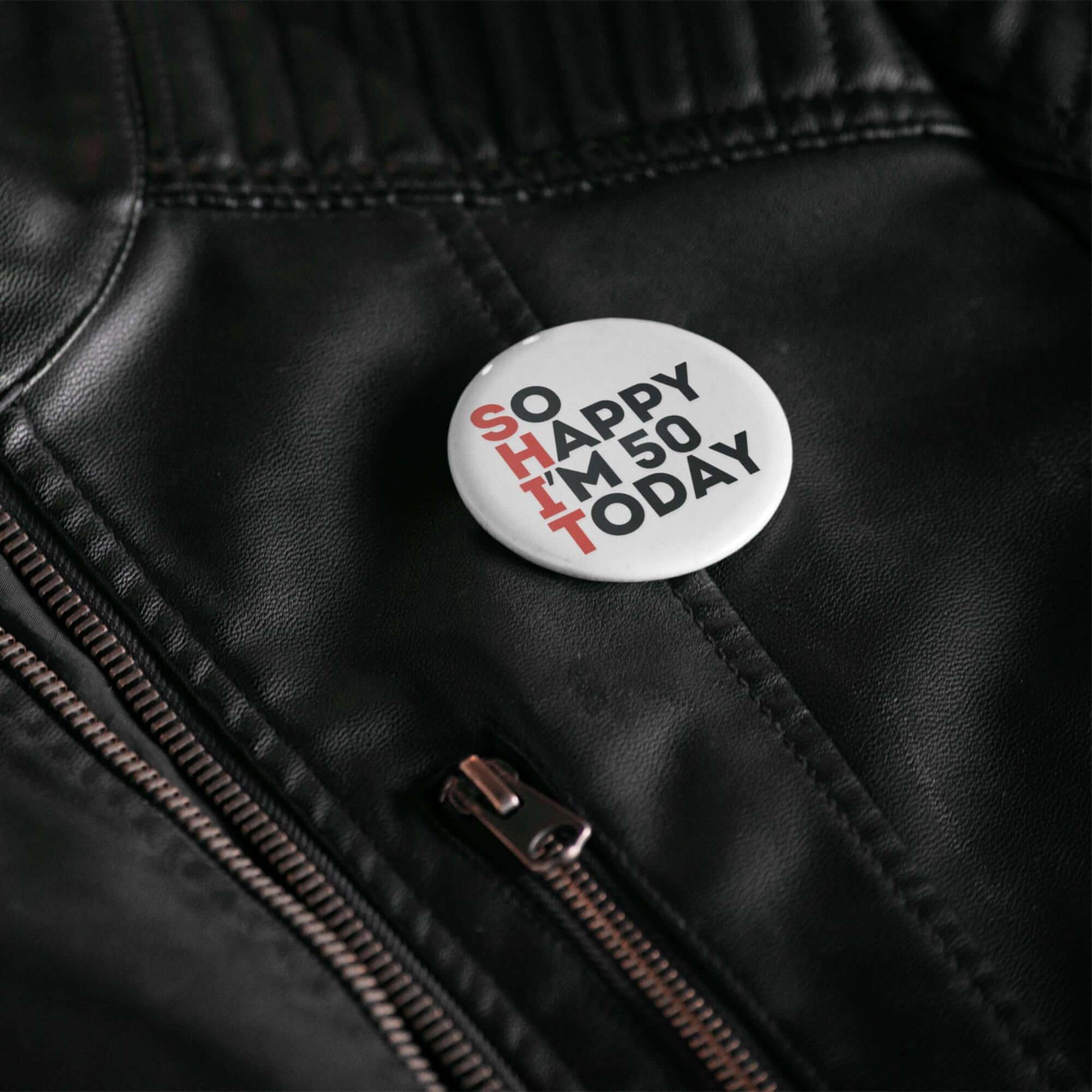50th birthday badge with the text 'SO HAPPY I'M 50 TODAY' on a leather jacket.
