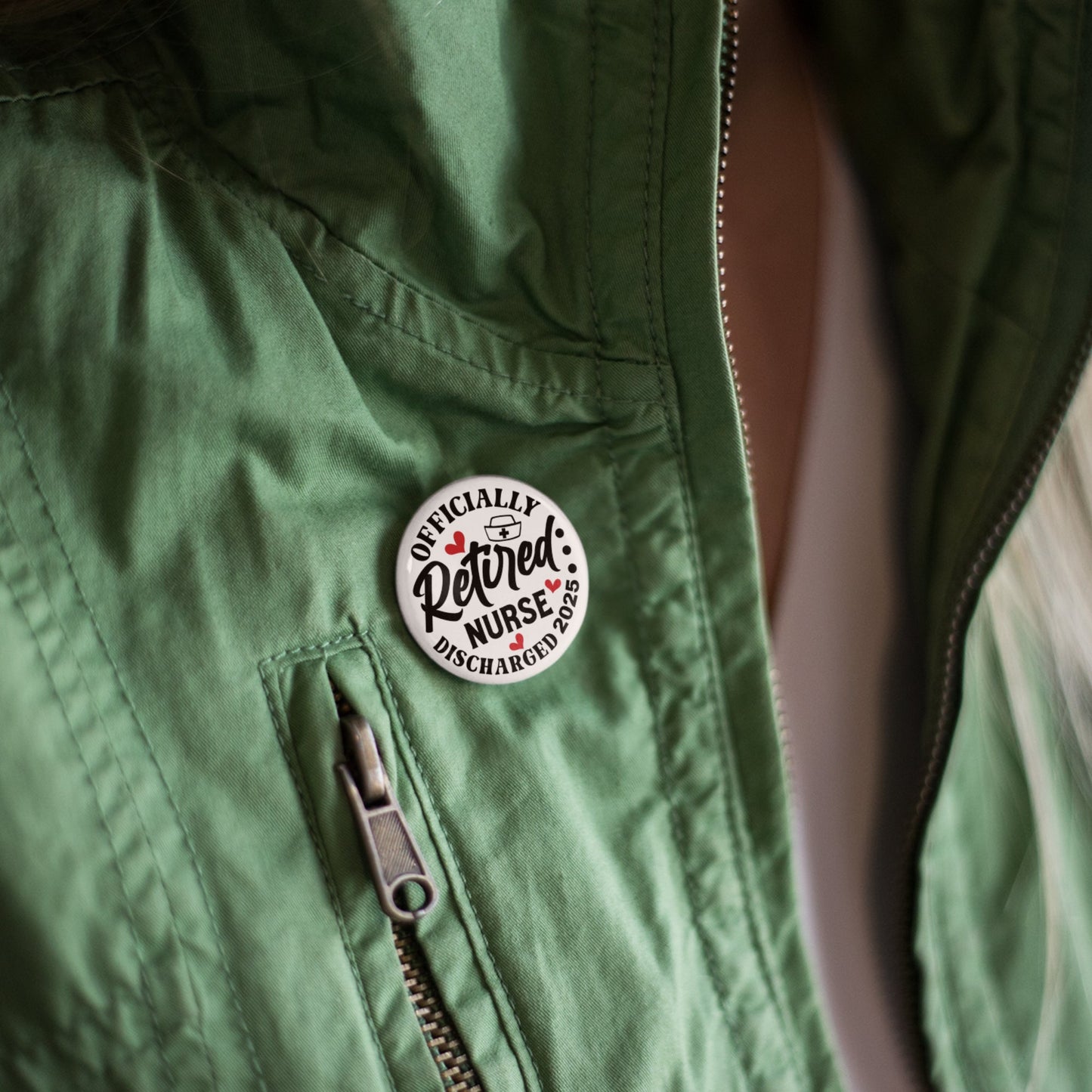 Retired Nurse Badge - Officially Retired 1 Inch Health Awareness Pin Button Badge worn on a green jacket, showcasing its versatility.