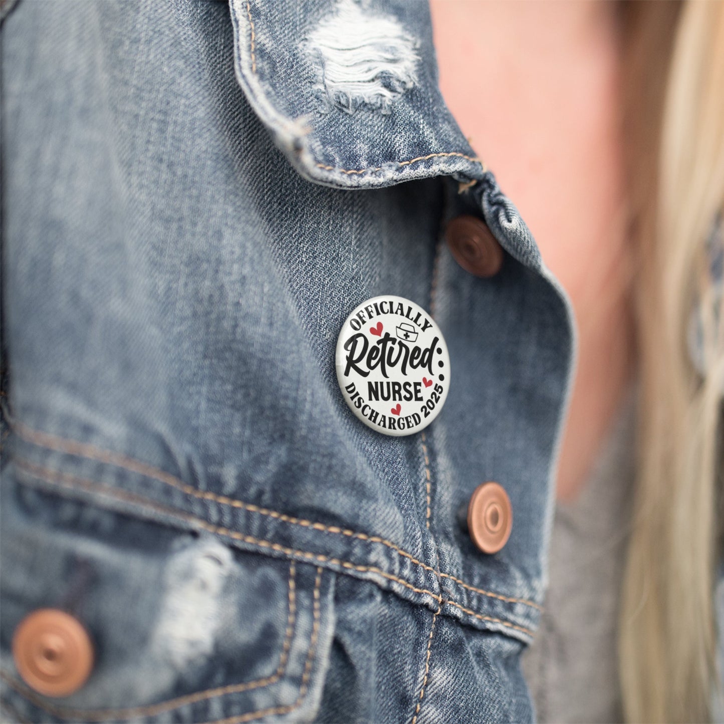 The Retired Nurse Badge - Officially Retired 1 Inch Health Awareness Pin Button Badge displayed on a denim jacket for a casual look.