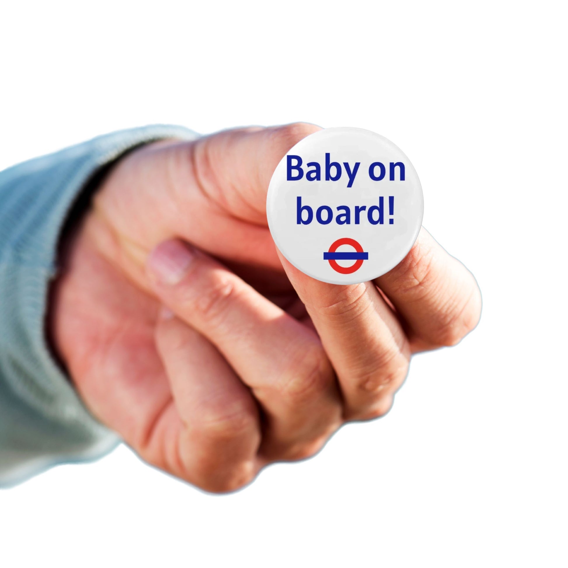 A person holding the Baby On Board Badge – London Underground Style Pregnancy Badge, showcasing a vibrant design for expectant mothers.