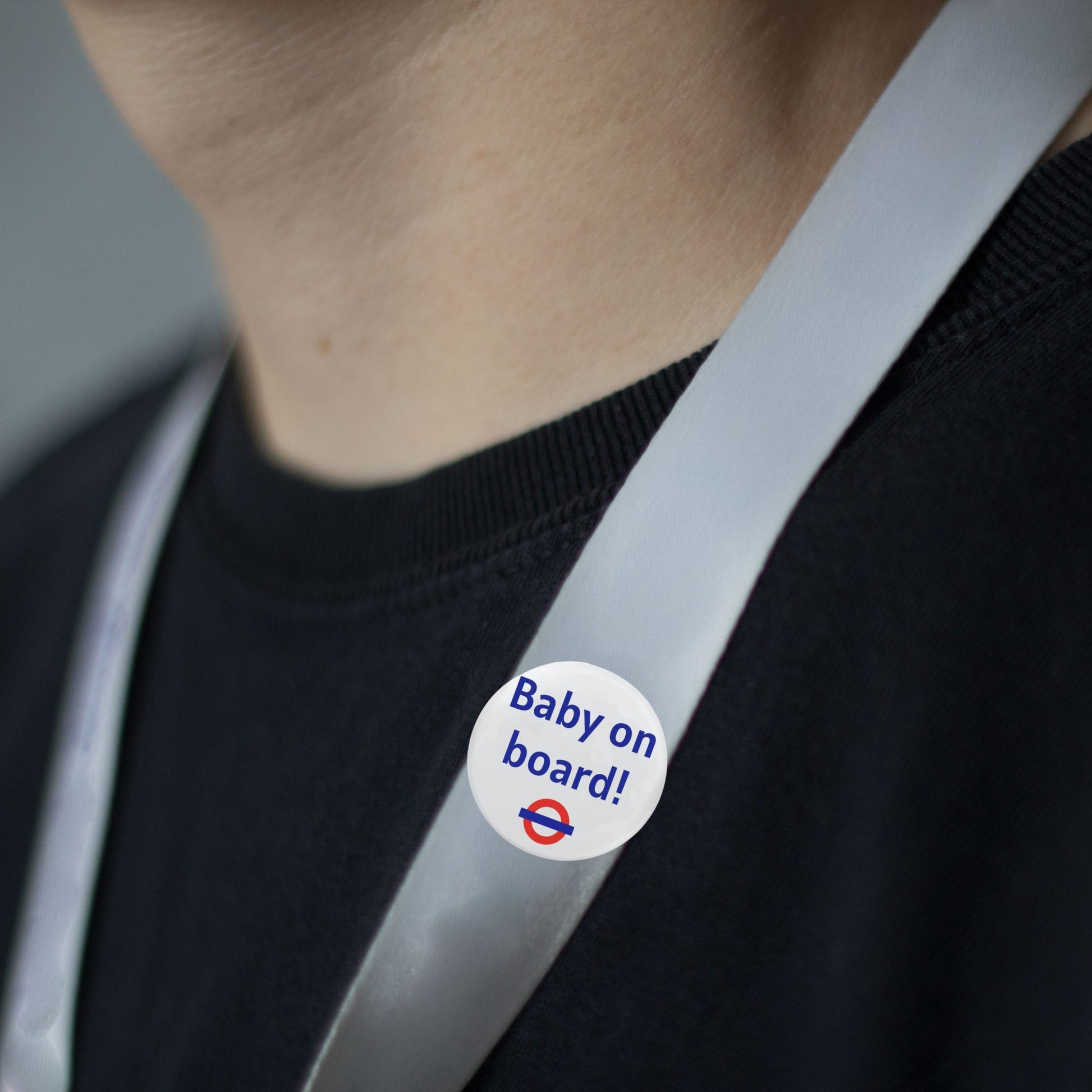 Close-up of the Baby On Board Badge – London Underground Style Pregnancy Badge pinned to a lanyard, ideal for public transport.