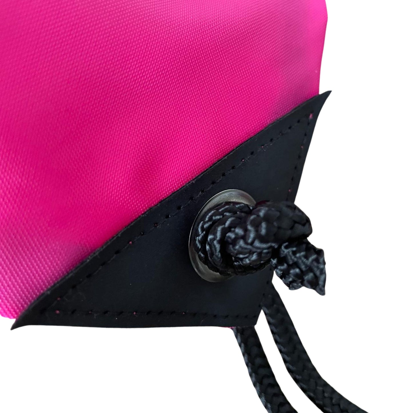 Close-up of a pink bag with black leather strap and knot on a white background