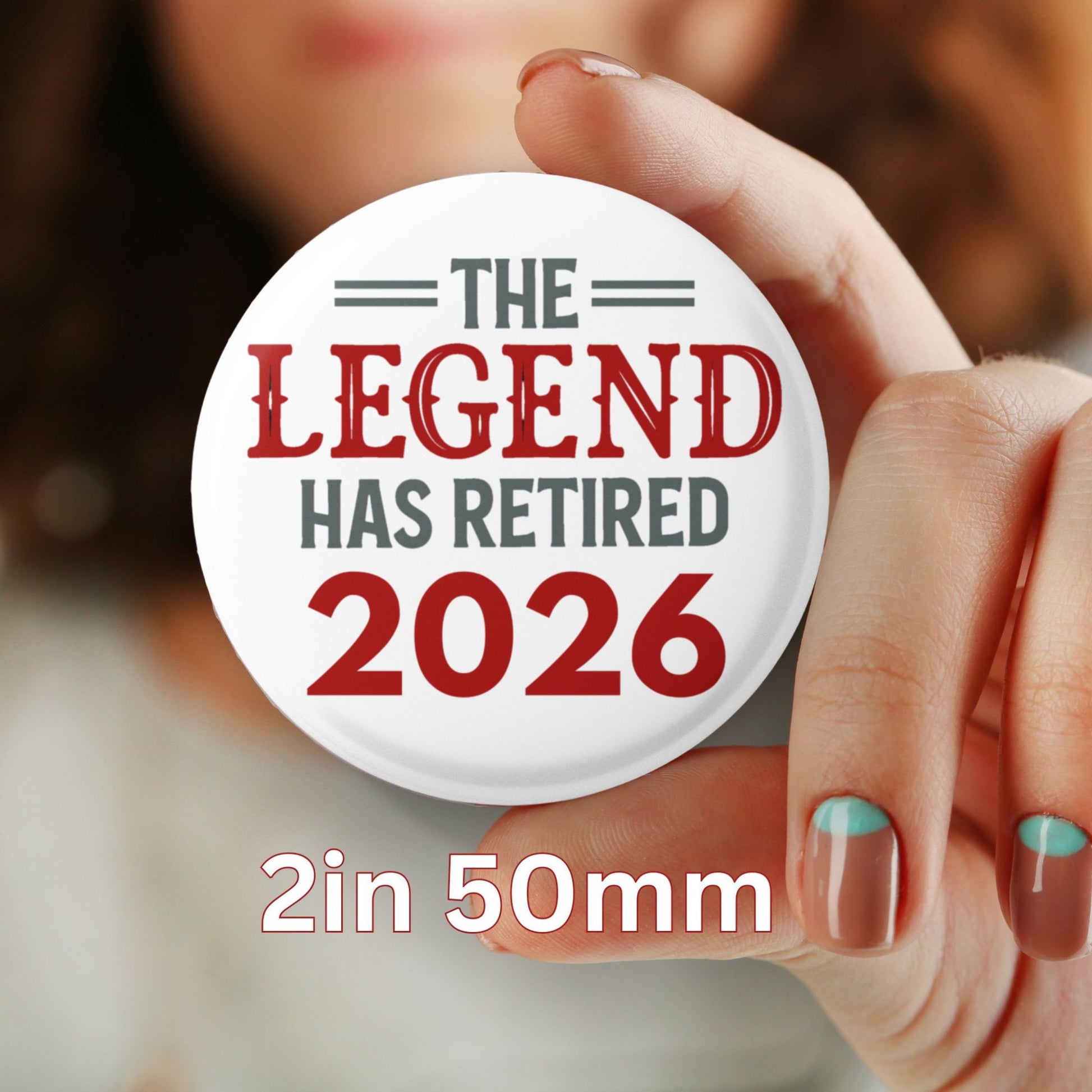 Button badge with 'The Legend Has Retired 2026' text held by a hand.
