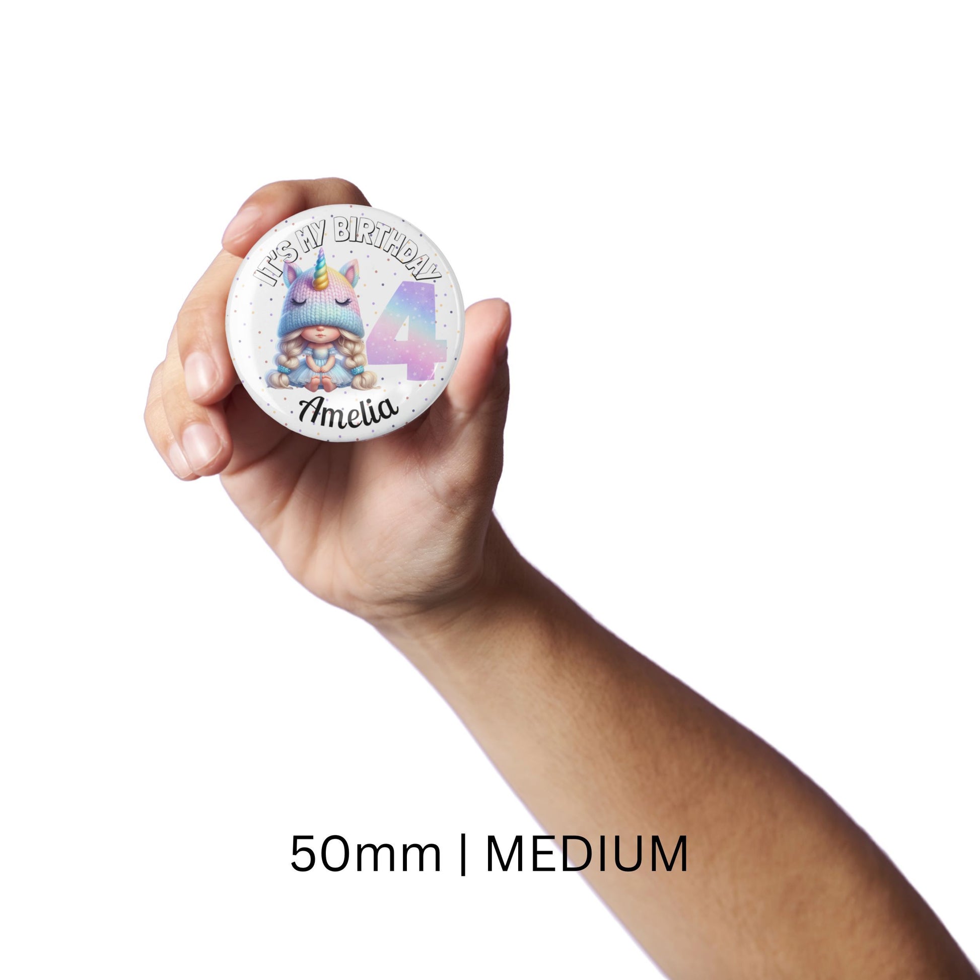 Hand holding a round badge with a unicorn design and text, labeled '50mm | MEDIUM'.