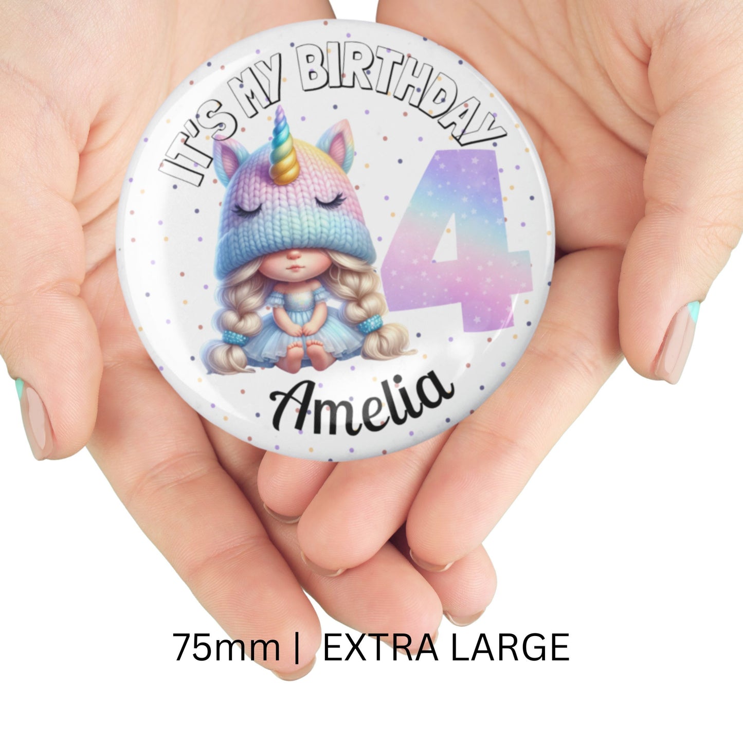 Button badge with unicorn design and text 'It's my birthday 4 Amelia' held in hands.