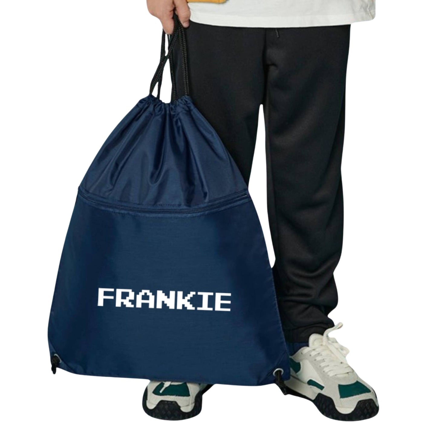 Navy drawstring bag with 'FRANKIE' branding held by a person wearing black pants and white sneakers.