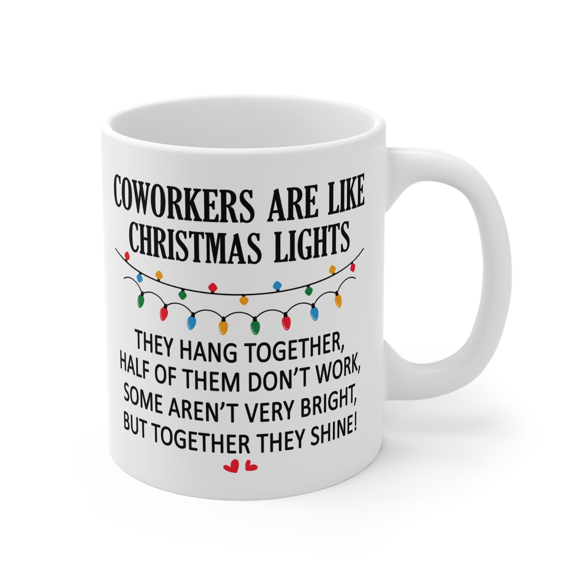 A white ceramic coffee mug with a humorous Christmas-themed coworking quote printed in black text, decorated with a colorful string of lights graphic and small red hearts at the bottom.