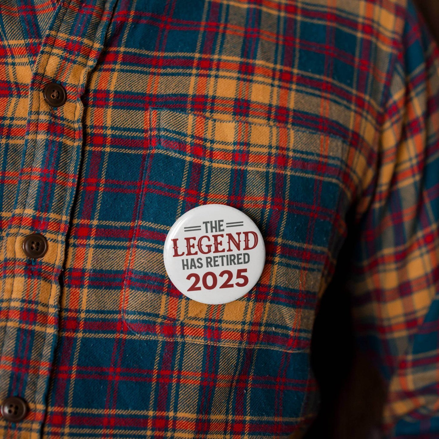 EMUWORKS Retirement Badge on plaid shirt, celebrating 'The Legend Has Retired 2025' in a stylish design.