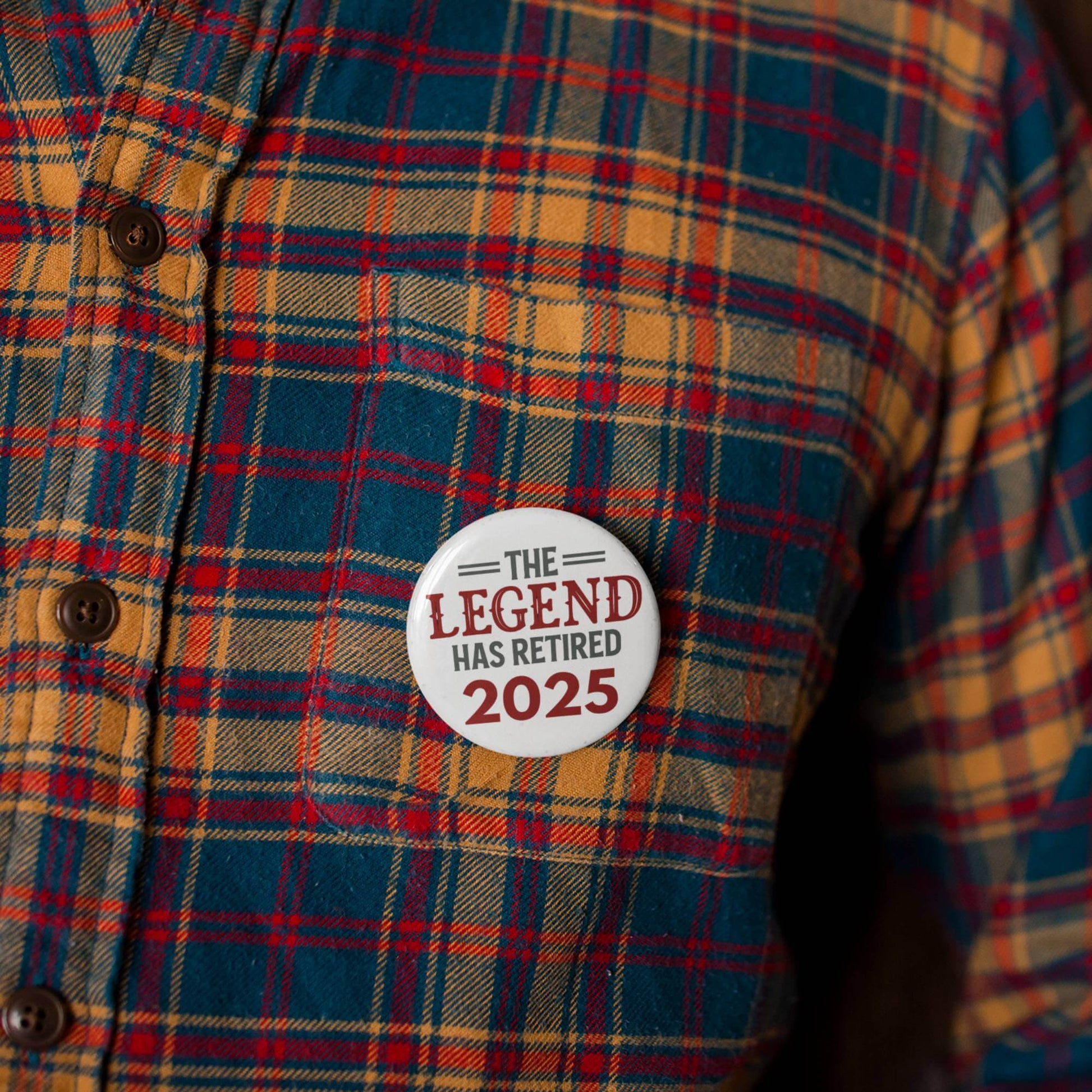EMUWORKS Retirement Badge on plaid shirt, celebrating 'The Legend Has Retired 2025' in a stylish design.